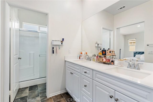 full bath with a stall shower, double vanity, and a sink