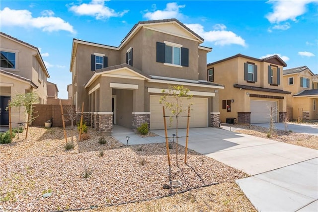 traditional-style house featuring concrete driveway, stucco siding, stone siding, a garage, and fence