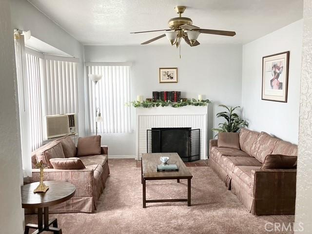 242 E 116th St, Los Angeles, CA 90061 - living area with carpet, ceiling fan, cooling unit, and a brick fireplace