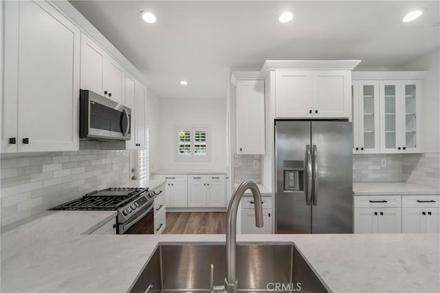 kitchen with a sink, white cabinetry, and stainless steel appliances