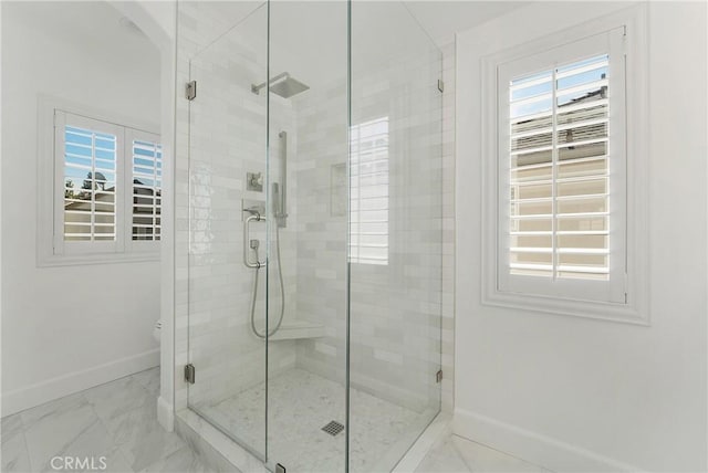 full bathroom with a shower stall, marble finish floor, baseboards, and toilet