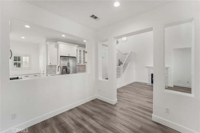 unfurnished living room featuring baseboards, recessed lighting, and wood finished floors