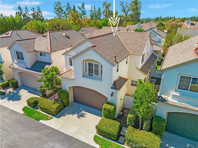 view of front of property with an attached garage, a residential view, driveway, and stucco siding