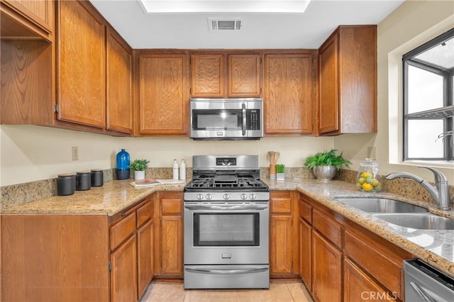 kitchen with brown cabinets, a sink, and stainless steel appliances