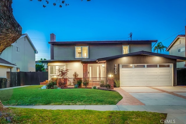 4903 Spencer St, Torrance, CA 90503 - traditional-style house with covered porch, fence, a front lawn, a garage, and driveway