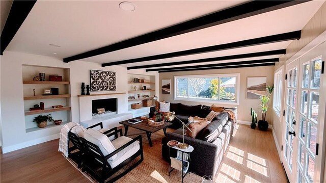 4903 Spencer St, Torrance, CA 90503 - living area featuring built in features, baseboards, a fireplace with raised hearth, and beamed ceiling
