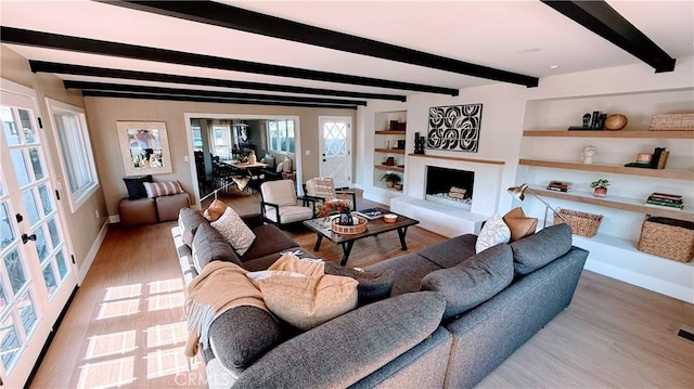 4903 Spencer St, Torrance, CA 90503 - living room with beamed ceiling, built in shelves, a fireplace with raised hearth, and wood finished floors
