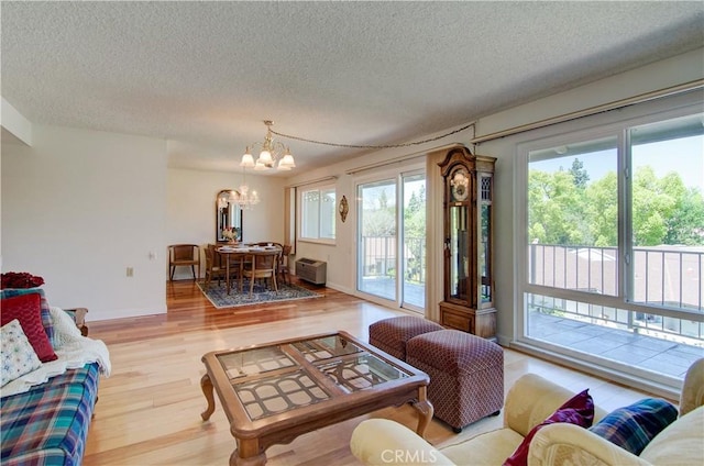 606 Avenida Sevilla Unit O, Laguna Woods, CA 92637 - living room featuring an inviting chandelier, wood finished floors, and a textured ceiling