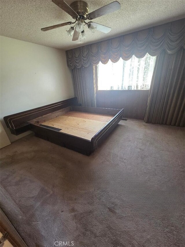 bedroom featuring a ceiling fan, carpet floors, access to outside, and a textured ceiling