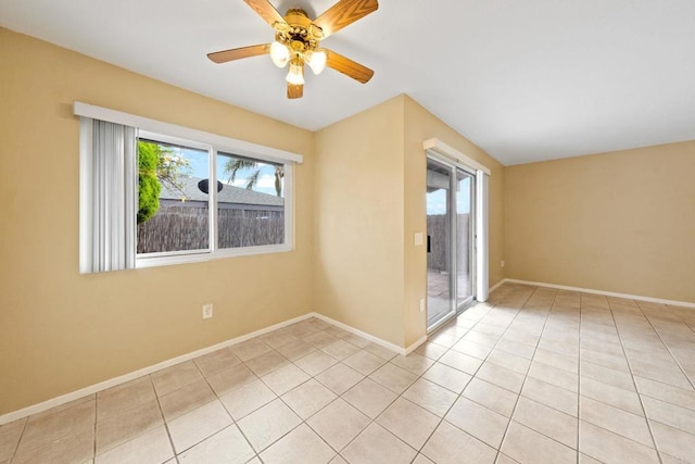 spare room with tile patterned floors, baseboards, and a ceiling fan