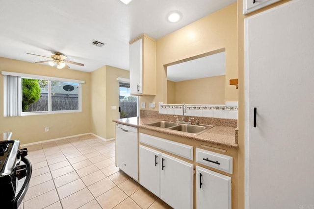 kitchen featuring white dishwasher, gas range oven, plenty of natural light, and a sink