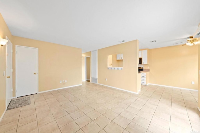 interior space with ceiling fan, baseboards, visible vents, and light tile patterned floors