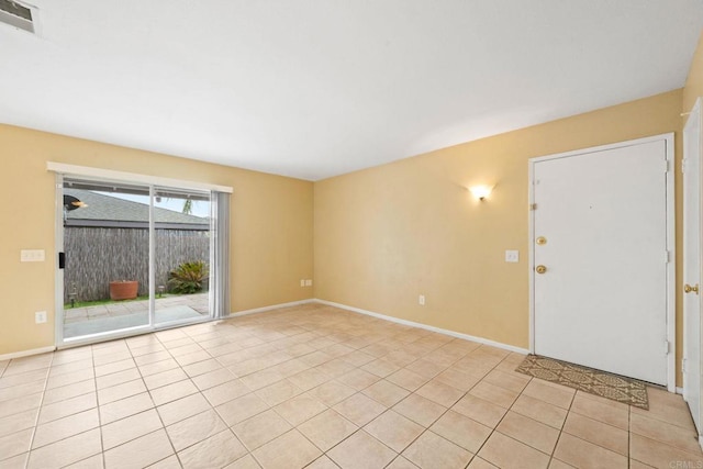 unfurnished room featuring baseboards, visible vents, and light tile patterned floors