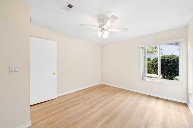 unfurnished room featuring light wood-type flooring, visible vents, a ceiling fan, and baseboards
