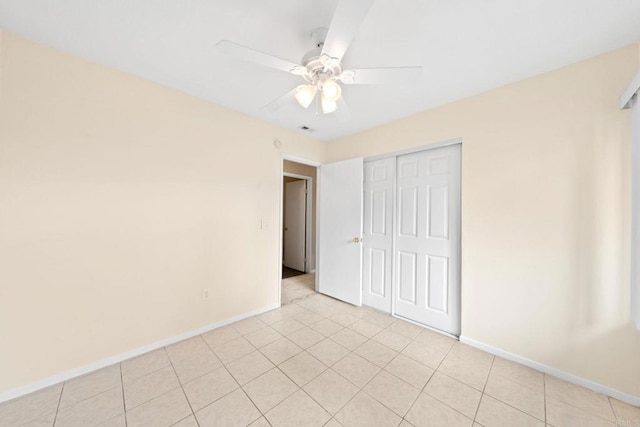unfurnished bedroom featuring light tile patterned floors, baseboards, a closet, and ceiling fan