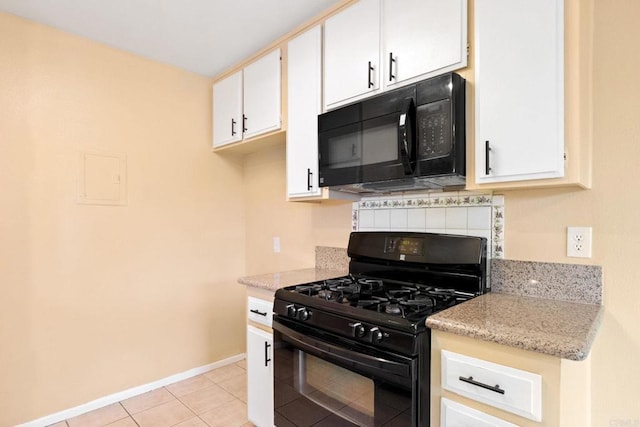 kitchen featuring light stone counters, black appliances, light tile patterned floors, white cabinets, and baseboards