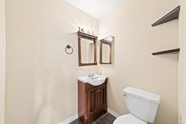 half bathroom with baseboards, vanity, tile patterned flooring, and toilet