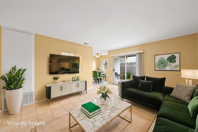 living area with ceiling fan, baseboards, visible vents, and light tile patterned floors