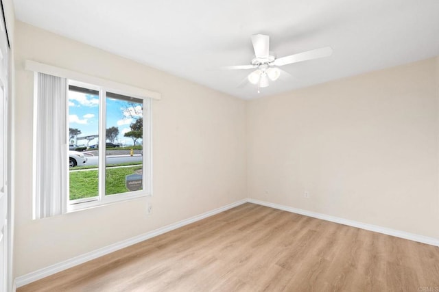 unfurnished room featuring light wood finished floors, a ceiling fan, and baseboards