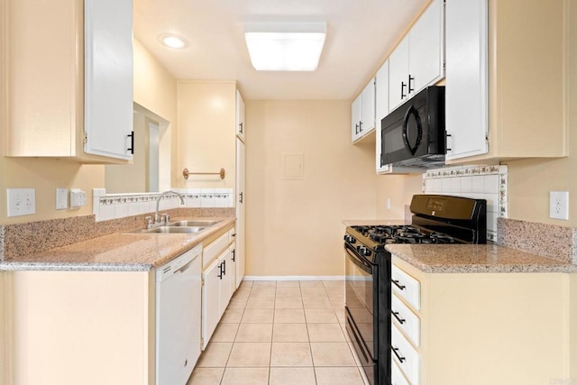 kitchen featuring light tile patterned floors, a sink, baseboards, black appliances, and white cabinetry