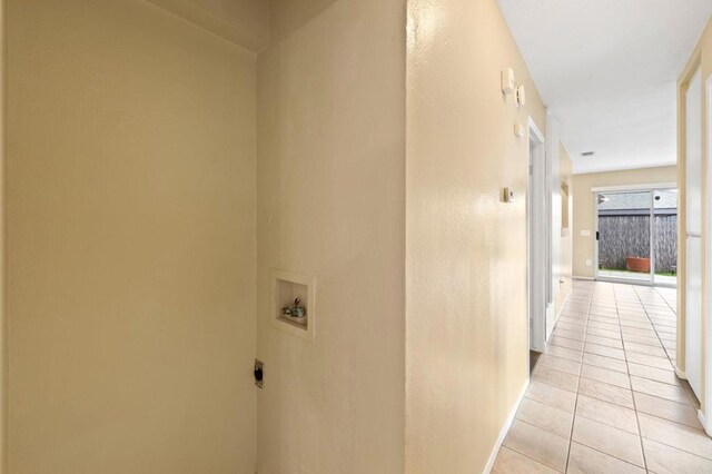 hallway featuring baseboards and light tile patterned floors