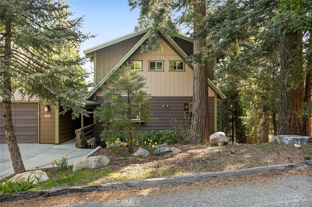 229 Chippewa Ln, Lake Arrowhead, CA 92352 - view of front facade with board and batten siding, a garage, and driveway