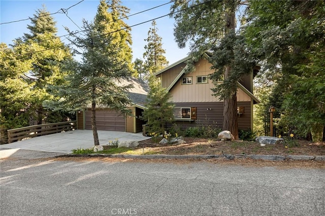 229 Chippewa Ln, Lake Arrowhead, CA 92352 - rustic home with driveway, board and batten siding, and an attached garage