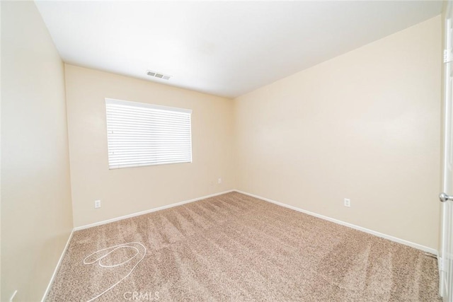 carpeted spare room featuring baseboards and visible vents