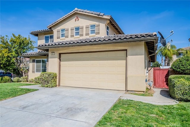 mediterranean / spanish home with a tiled roof, concrete driveway, stucco siding, and a front yard