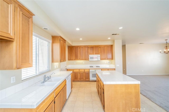kitchen with recessed lighting, white appliances, a center island, tile countertops, and a sink