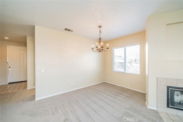 unfurnished living room featuring visible vents, baseboards, carpet flooring, and an inviting chandelier