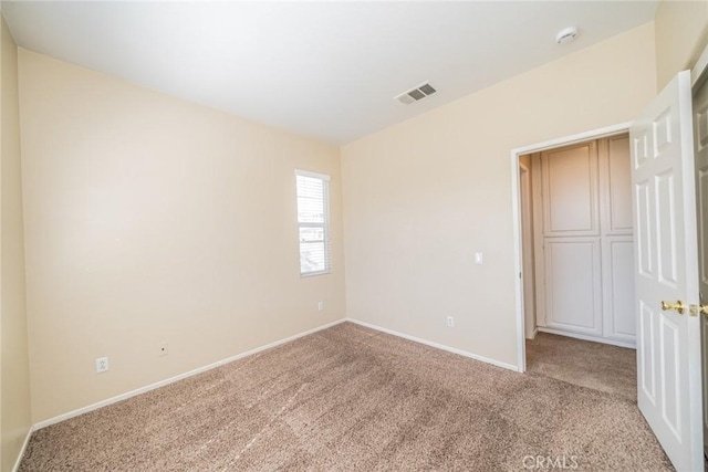 unfurnished bedroom with visible vents, baseboards, and carpet flooring
