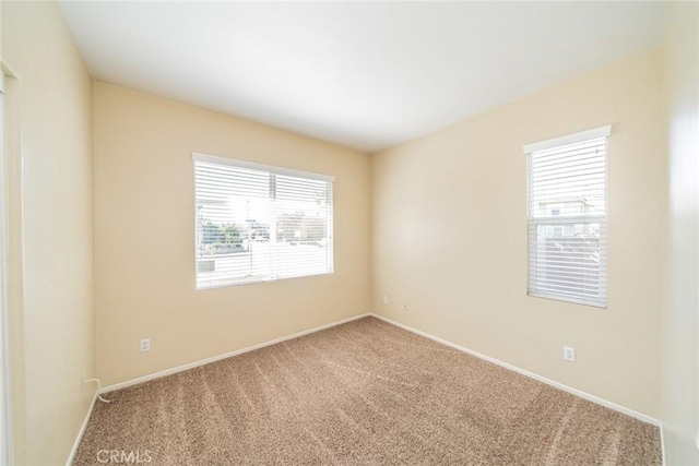 carpeted spare room with baseboards