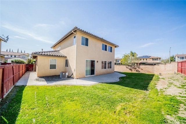 back of property with a fenced backyard, stucco siding, a patio area, and a lawn