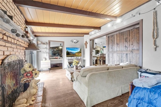 living area with beamed ceiling, wooden ceiling, and wood finished floors