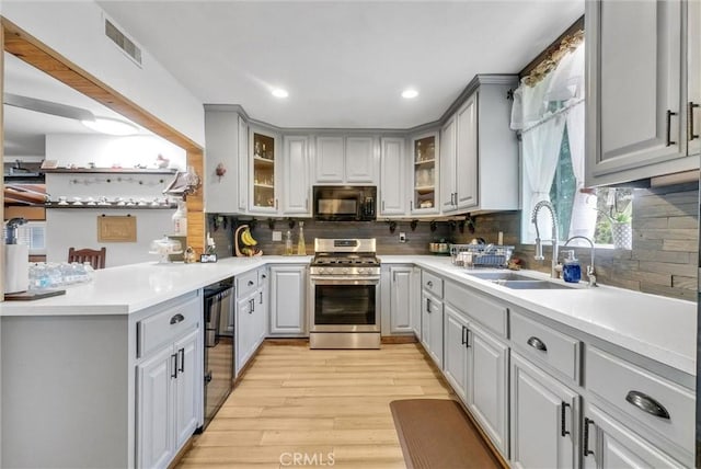 kitchen with gas stove, gray cabinetry, and black microwave