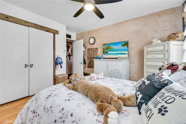 bedroom with light wood finished floors, a closet, and ceiling fan