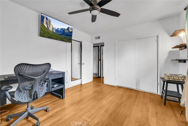 home office with visible vents, a ceiling fan, and wood finished floors