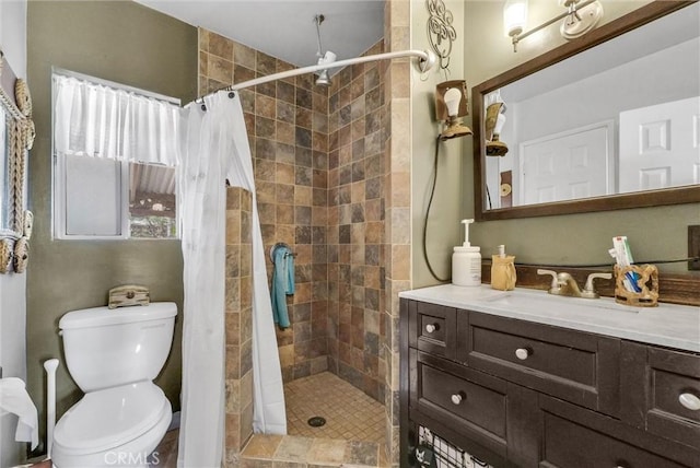 full bath with toilet, tiled shower, and vanity