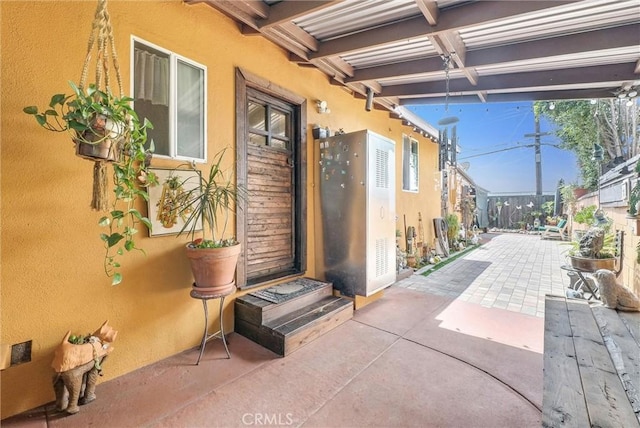 property entrance featuring a patio area and stucco siding