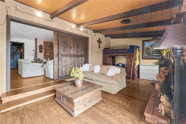 living area featuring beamed ceiling, wood finished floors, and wood ceiling