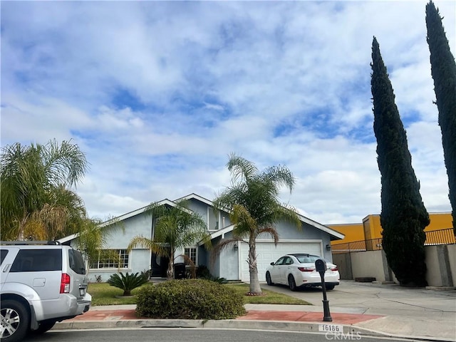 single story home with an attached garage, fence, and driveway