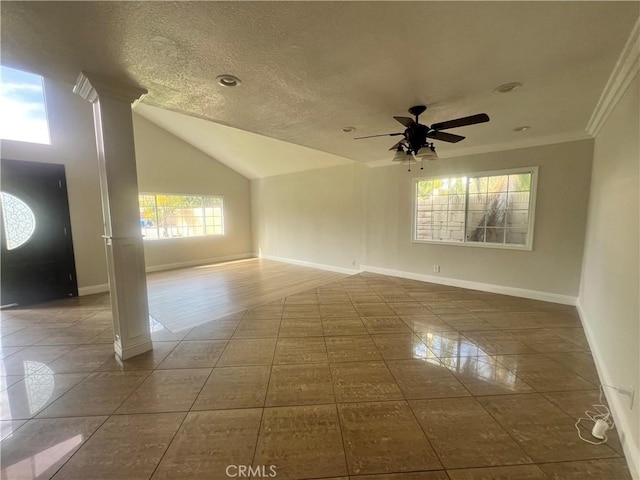 tiled empty room featuring baseboards, a ceiling fan, decorative columns, crown molding, and vaulted ceiling