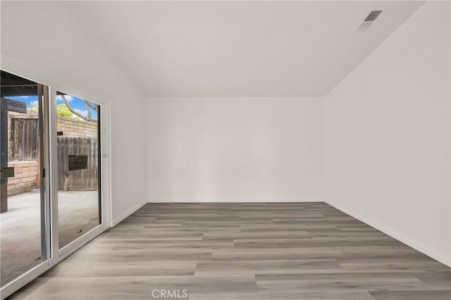 spare room with visible vents, baseboards, and wood finished floors