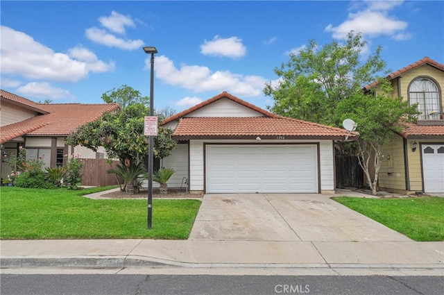 view of front of house featuring concrete driveway, a tiled roof, fence, a front yard, and a garage