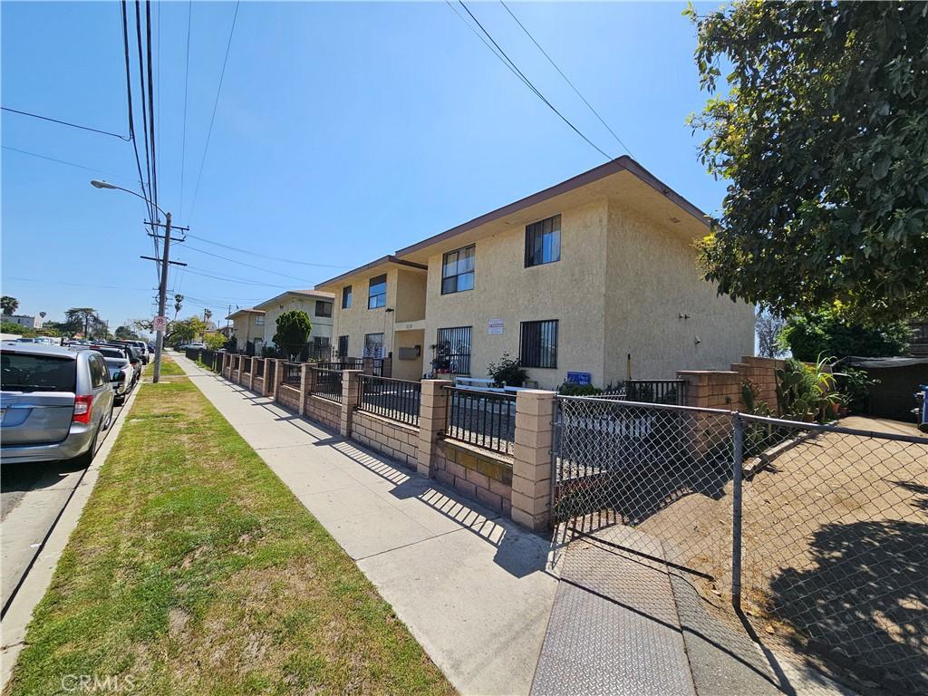 view of side of property with stucco siding and fence