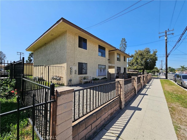 view of home's exterior with fence, a gate, and stucco siding