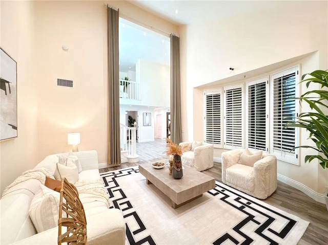 living area with visible vents, baseboards, and wood finished floors
