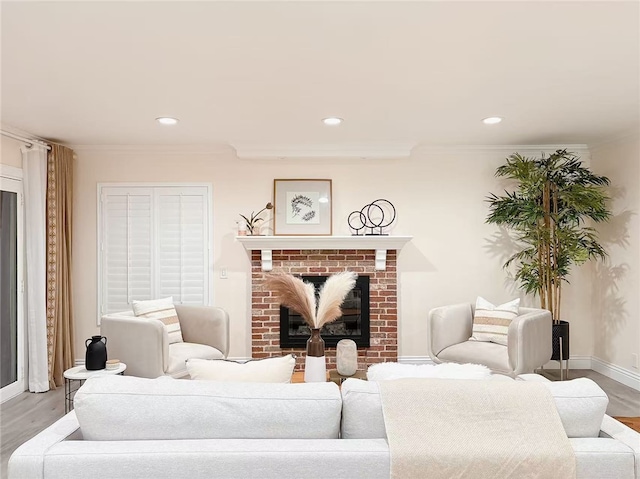 living room featuring recessed lighting, a brick fireplace, crown molding, and wood finished floors