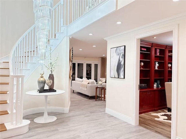 entryway featuring ornamental molding, recessed lighting, stairway, a high ceiling, and wood finished floors
